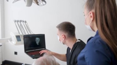 Profesyonel dişçi yaşlı hastasıyla çalışıyor, dişçiyi ziyaret eden yaşlı bir adam klinikteki dişleri, dişçiliği, sağlık hizmetlerini, insan sigortasını inceliyor. Yüksek kalite 4k video