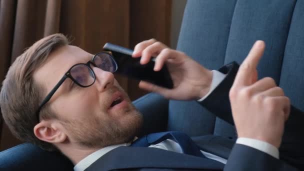 Mladý Bohatý Muž Obleku Mluví Telefonu Zatímco Leží Pohovce Kanceláři — Stock video