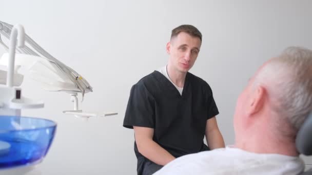 Літній Чоловік Призначається Стоматологів Вони Весело Спілкуються Під Час Огляду — стокове відео