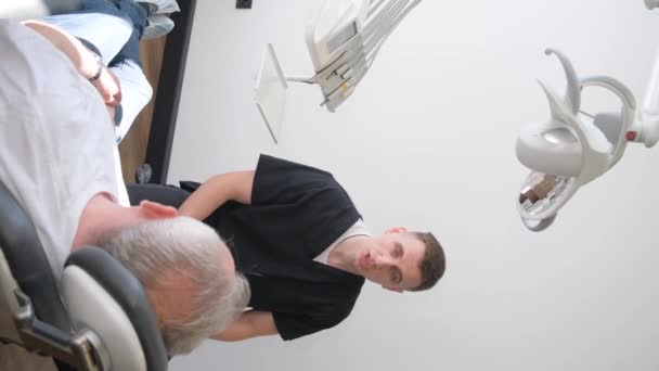 Pensionista Sentado Uma Cadeira Dentista Fala Sobre Seus Problemas Dentários — Vídeo de Stock