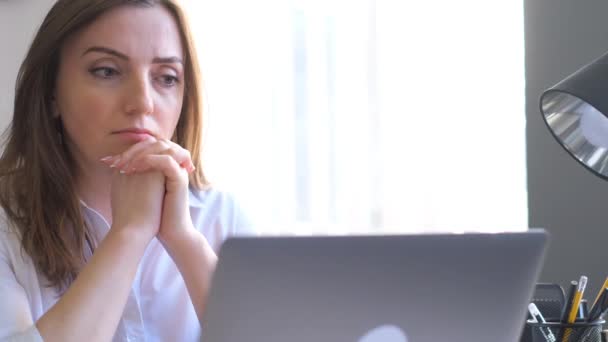 疲れている女性のオフィスマネージャーは コンピュータの前に彼女の机に座っている オフィスの仕事から頭痛だ 4Kビデオ — ストック動画