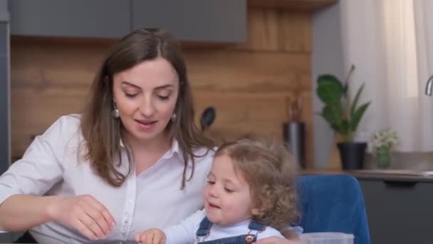 Krásná Matka Objímá Svou Milující Dcerku Zatímco Sedí Stolu Kuchyňském — Stock video