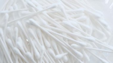 Pamuk kulaklıkların daireler çizerek döndüğü bulanık bir video. Kulaklar için hijyen ürünleri. Dikey video