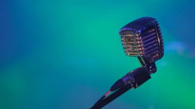 Mikrofon standındaki profesyonel mikrofon parlak renklerle aydınlatılıyor. Konserdeki sahne. Yüksek kalite 4k video