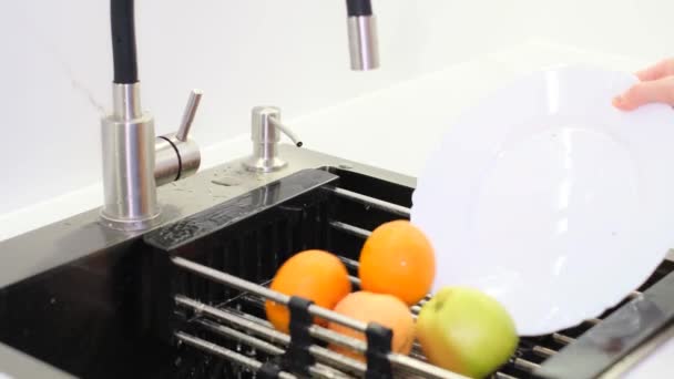 新鮮な果物を洗うのクローズアップ 洗濯棚に女がぬれた果物を投げ込む — ストック動画