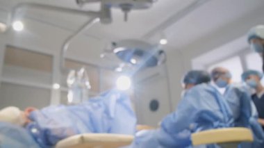 Doktorların ve cerrahların çalışmalarının geçmişi bulanık. Klinikte gerçek bir ameliyat. 4k video