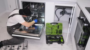 Profesyonel bir tesisatçı mutfak lavabosunu tamir ediyor. Borularda su akışı. Evine bir tesisatçı çağır.