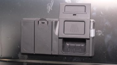 Bir kadın eli bulaşık makinesinin içine kimyasal tablet yerleştirir. Modern teknolojileri kullanarak yüksek kaliteli bulaşık yıkama