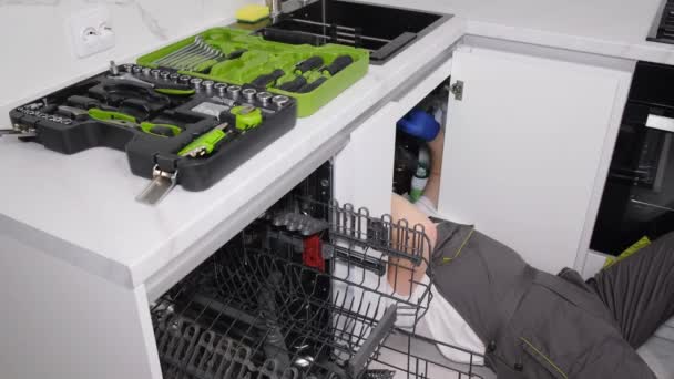 Ein Klempner Arbeitet Auf Dem Boden Liegend Der Küche Installiert — Stockvideo
