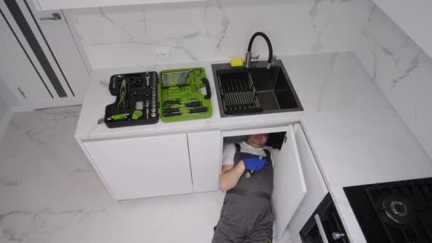Άντρας Υδραυλικός Επισκευάζει Σωλήνες Νεροχύτη Στην Κουζίνα Υψηλής Γωνίας Άποψη — Αρχείο Βίντεο