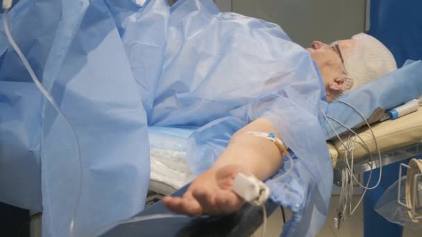 老女が手術室の手術台にいて麻酔中に医者と話をしている 現代ヨーロッパクリニック — ストック動画