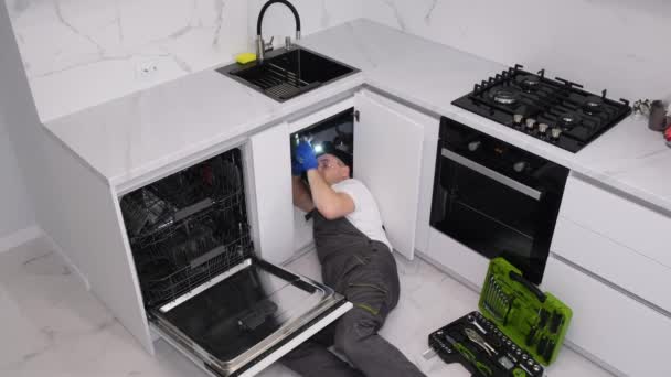 Encanador Trabalha Deitado Chão Cozinha Ele Instala Uma Pia Trabalho — Vídeo de Stock