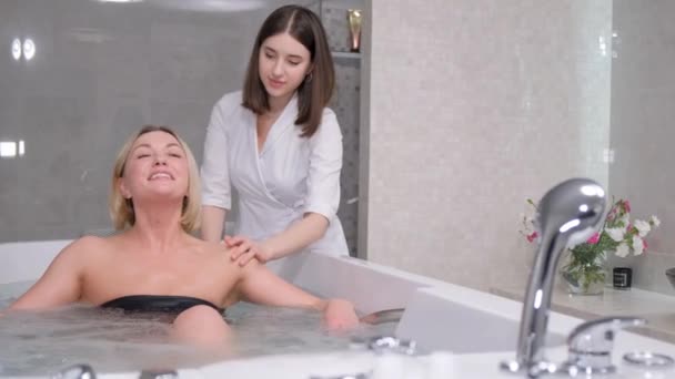 一位专业的美容师在温泉中心对背部进行水疗按摩 在水程序的帮助下处理背部 洗澡时放松 — 图库视频影像