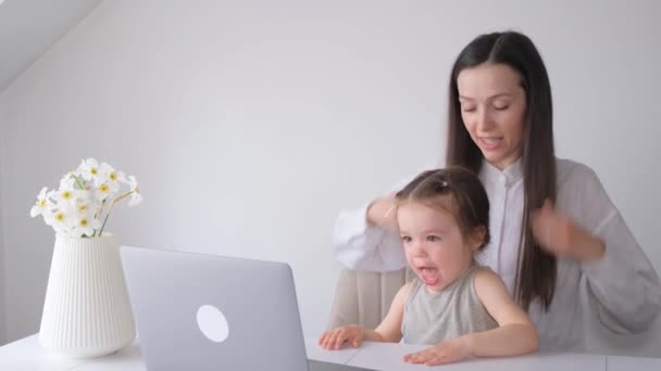 ビジネスの女性は子供と家でノートパソコンで働いています 子供は母親の仕事に干渉する 高品質4Kビデオ — ストック動画