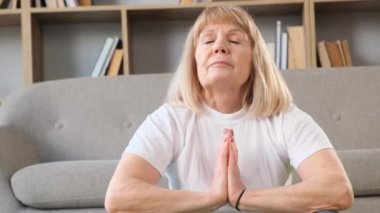 Yoga yapan yaşlı, sarışın bir kadının portresi. Meditasyon. Kendinle uyum içinde. Dikey video