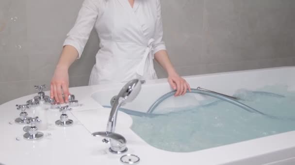 一位女医生用豪华温泉把热水澡灌满了水 放松美容中心的程序 垂直录像 — 图库视频影像