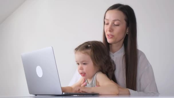Young Mother Soothes Her Little Daughter Letting Her Play Laptop — Stock Video