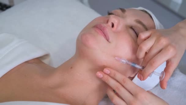 美容師は美しい女性の顔に若返り抗しわ注射を行います 化粧品手術コンセプト — ストック動画