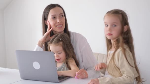 自宅のノートパソコンで働いている2人の子供を持つ母親 ビジネスの女性が遠隔操作で — ストック動画