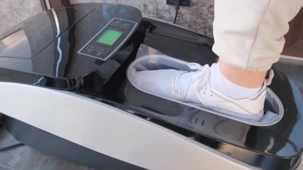 Zbliżenie Mężczyzny Zakładającego Ochraniacze Buty Automatycznej Maszynie Koncepcja Czystości Higieny — Wideo stockowe