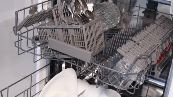 現代の食器洗い機に台所用品を置く女性の手のクローズアップ 家の中の清潔感の概念 — ストック動画