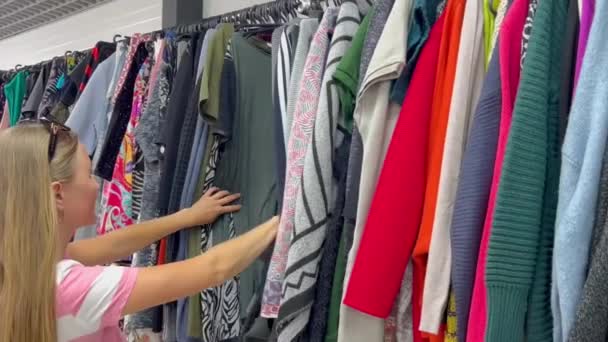 Σειρές Μεταχειρισμένων Ρούχων Κρέμονται Από Κρεμάστρες Μια Γυναίκα Αγοράζει Μεταχειρισμένα — Αρχείο Βίντεο