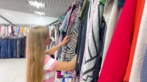 店内で使用する服 若い女性が買い物をする バーティカルビデオ — ストック動画
