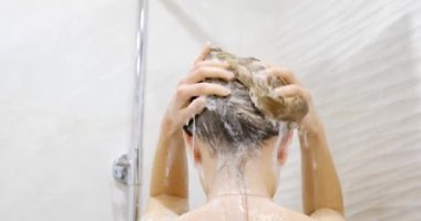 Saçını şampuanla yıkayan bir kadın. Duş alıyor Uzun saçlar.