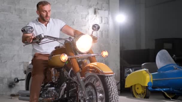 一个骑摩托车的男人离开了车库 自行车业余爱好 漂亮的摩托车 — 图库视频影像