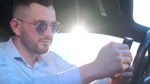 Handsome Man Sunglasses Sits Car Holds Smartphone Young Businessman — ストック動画