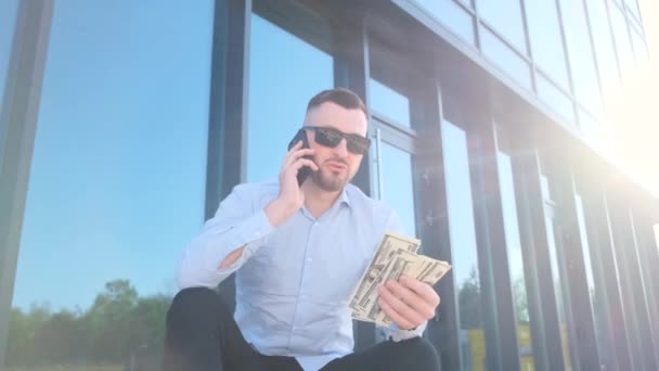 Young Man Blue Shirt Sits Steps Front Office Holds Dollar — Stock Video