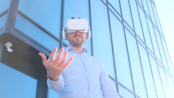 Business Man Uses Virtual Reality Glasses Waving His Hands Background — стокове відео