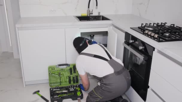 Young Plumber Wearing Gray Uniform Fixing Sewer Pipe Kitchen Unfinished — Αρχείο Βίντεο