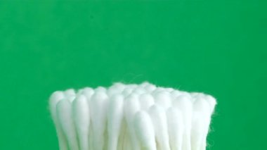 Cotton swabs on a green background. Chromakey background. Close-up.