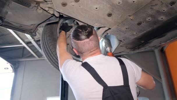 Young Car Mechanic Replaces Wheel Brake Pads Lifted Car Repair — стокове відео
