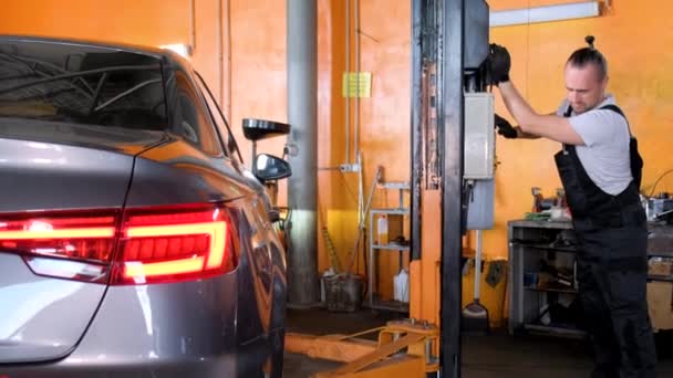 Young Car Mechanic Replaces Wheel Brake Pads Lifted Car Repair — Vídeo de stock