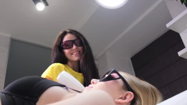 Positive Smiling Beautician Epilates Young Womans Face Protective Glasses Laser — Stockvideo