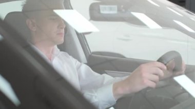 The buyer inspects the interior of a new car. Buying a new electric car at a dealership.