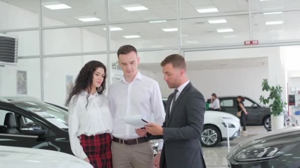 Young Couple Buys Car Credit Car Sales Manager Showing New — стоковое видео