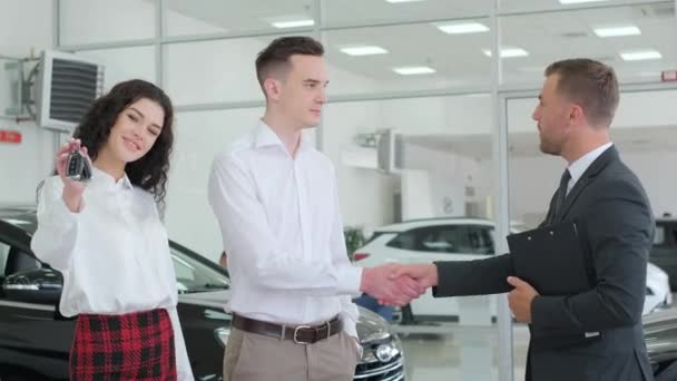 Car Dealer Consults Young Couple Car Dealership Professional Employee Helping — стокове відео
