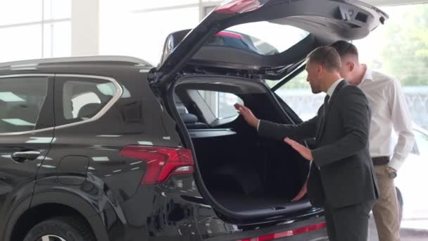 Young Man Talking Car Salesman Guy Client Buys Vehicle Showroom — стокове відео