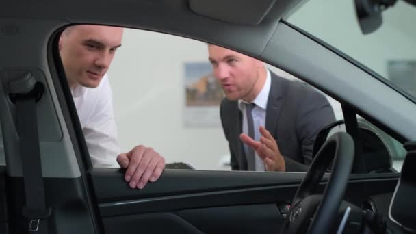 Young Man Talking Car Salesman Guy Client Buys Vehicle Showroom — стокове відео
