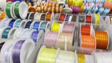 Colorful rolled up ribbons for sale in a textile shop. Close up.