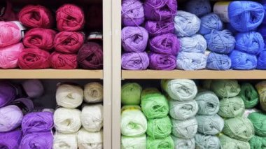 Colorful balls of wool on the shelf. Different balls of yarn of different colors. Slow motion.