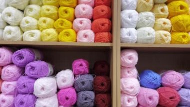 Many colorful balls of wool yarn in a fabric store. Background from colored cotton yarn. Balls of thread in the store