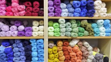 Woolen threads of different colors in the store on the shelf.