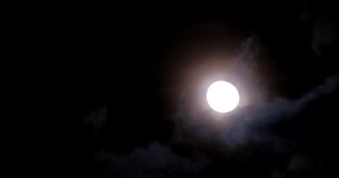 Full moon at night with thick clouds. Time lapse of the night sky.