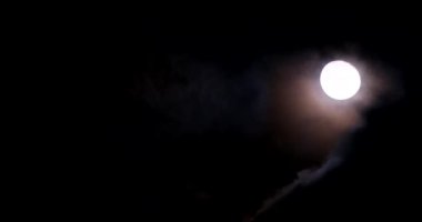 A bright yellow moon at night among the clouds. Astrology concept.