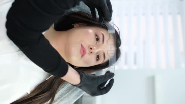 Vertical Video Beautician Performing Permanent Eyebrow Make Procedure Using Special — стоковое видео