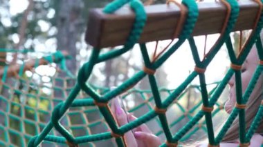 Young woman resting in a hammock in a hammock in the forest. Relaxing in the hotel yard.